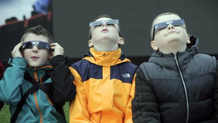 Les &eacute;coliers de Glasgow (Ecosse, Royaume-Uni) tentent d'observer l'&eacute;clipse solaire, le 20 mars 2015.&nbsp; (ANDY BUCHANAN / AFP)