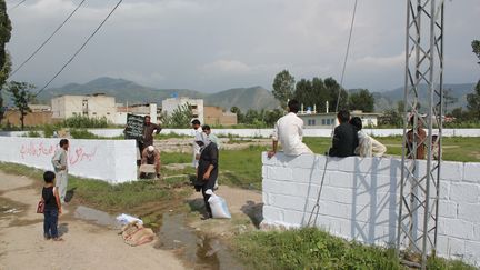 Des employés pakistanais marquent les angles de la parcelle où était bâtie la résidence d'Oussama Ben Laden, samedi 23 juillet, rasée après sa mort. (SHAKEEL AHMED / AFP)