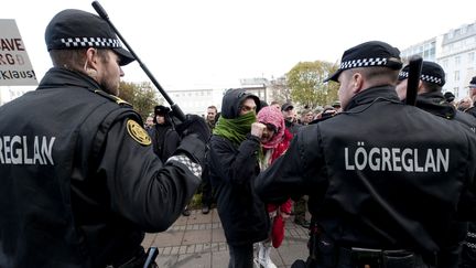 Deux policiers montent la garde devant le Parlement islandais, le 1er octobre 2010, durant une manifestation contre les effets de la crise financi&egrave;re, &agrave; Reykjavik. (HALLDOR KOLBEINS / AFP)