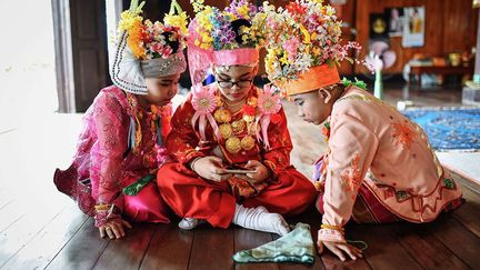 et parés de bijoux scintillants. Leurs têtes sont couvertes de turbans colorés et de fleurs. (Li Mangmang/Xinhua/Sipa)