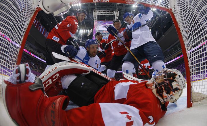 Les joueurs canadiens accul&eacute;s sur leur but lors du match Canada-Finlande, du tournoi olympique de hockey sur glace, &agrave; Sotchi (Russie), le 16 f&eacute;vrier 2014.&nbsp; (MARK BLINCH / AFP)