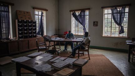 Si Anicet Bahidika (au centre), responsable du département de la documentation, parle avec fierté des trésors présents par milliers au CRSN (livres anciens, objets d'art, spécimens naturels…), il évoque aussi auprès de l'AFP, les nombreuses difficultés rencontrées au quotidien.&nbsp;&nbsp; (GUERCHOM NDEBO/AFP)