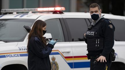 Des policiers aux abords de la bibliothèque de Lynn Valley, dans le nord de Vancouver, au Canada, où une attaque au couteau a eu lieu samedi 27 mars 2021. (JONATHAN HAYWARD / THE CANADIAN PRESS / AP)