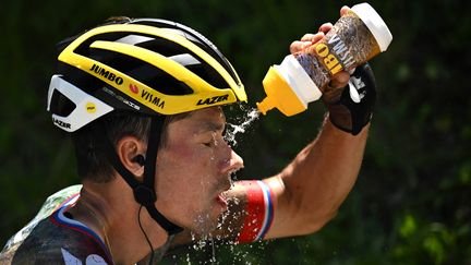 Le cycliste Primoz Roglic, de la Jumbo-Visma, tente de se rafrîchir avec son bidon d'eau, lors de la 11e étape du Tour de France 2022. (MARCO BERTORELLO / AFP)