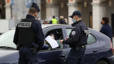 Deux policiers effectuent un contrôle du confinement, le 27 février, à Nice (Alpes-Maritimes). (VALERY HACHE / AFP)