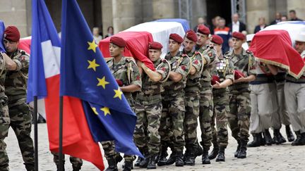 Le 21 ao&ucirc;t 2008, des militaires portent les d&eacute;pouilles des 10 soldats fran&ccedil;ais morts dans une embuscade &agrave; Uzbin, en Afghanistan, lors d'une c&eacute;r&eacute;monie aux Invalides &agrave; Paris.&nbsp; (MICHEL EULER / AFP)