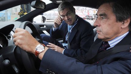 L'ex-Premier ministre Fran&ccedil;ois Fillon et le patron de PSA, Philippe Varin, le 11 juin 2011 dans une Peugeot RCZ, aux 24 heures du Mans. (JEAN-FRANCOIS MONIER / AFP)