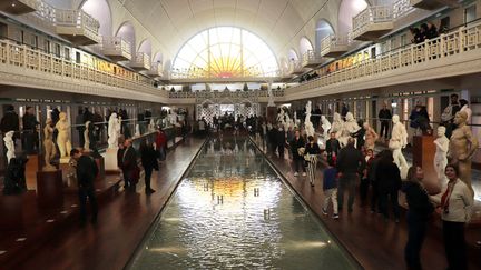 Des visiteurs autour du grand bassin de La Piscine de Roubaix admirent les œuvres et sculptures essentiellement Art déco. (FRANÇOIS CORTADE / FRANCE-BLEU NORD)