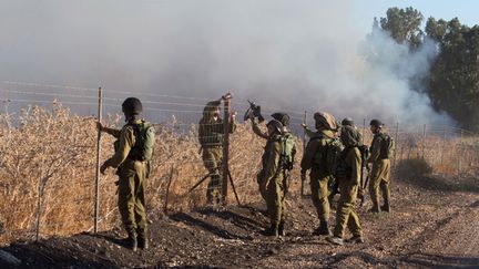 &nbsp; (Des soldats israéliens se tiennent à proximité d'un feu provoqué par un tir de roquettes © REUTERS/Stringer Shanghai)