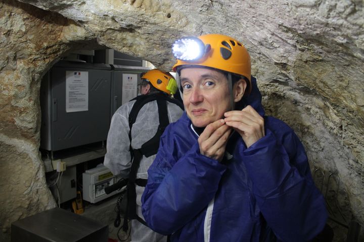 Une g&eacute;ologue de l'&eacute;quipe scientifique rev&ecirc;t sa tenue de sp&eacute;l&eacute;ologue avant de descendre dans la grotte Chauvet &agrave; Vallon-Pont-d'Arc, le 18 mars 2015. (JEROMINE SANTO GAMMAIRE / FRANCETV INFO )