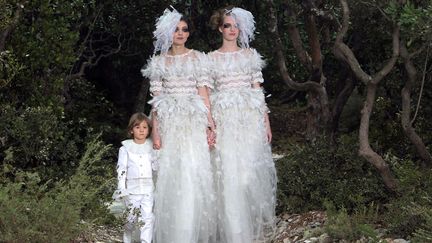 #LE MARKETINGInvit&eacute; surprise du d&eacute;bat, Chanel a profit&eacute; de son d&eacute;fil&eacute; haute couture pour se prononcer en faveur du mariage pour tous et faire d&eacute;filer deux jeunes mari&eacute;es et leur fils pour cl&ocirc;turer sa collection. Etonnant lorsque l'on sait que le directeur artistique de la maison de la rue de Cambon s'est auparavant d&eacute;clar&eacute; oppos&eacute; &agrave; ce m&ecirc;me mariage. Un joli coup marketing donc. (LOIC VENANCE / AFP)