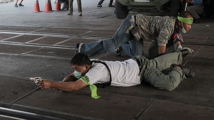 Un opposant au gouvernement tire en direction de manifestants militant pour la tenue des &eacute;lections l&eacute;gislatives &agrave; Bangkok (Tha&iuml;lande), le 1er f&eacute;vrier 2014. (NICOLAS ASFOURI / AFP)