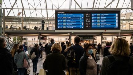 Des voyageurs attendent dans le hall de la gare de Lyon, à Paris, le 12 octobre 2021. (JC MILHET / HANS LUCAS / AFP)