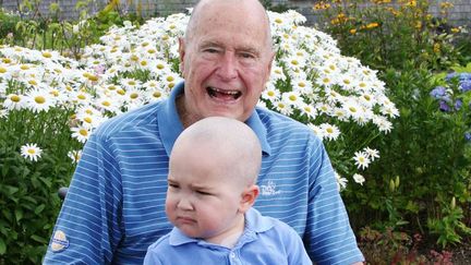 George H. W. Bush tient sur ses genoux le petit Patrick, &acirc;g&eacute; de 2 ans et atteint d'une leuc&eacute;mie, sur une photo publi&eacute;e le 24 juillet 2013 par son bureau. (AP / SIPA)