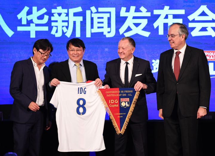 Jean-Michel Aulas, président de l'Olympique Lyonnais (2e D) et Xiong Xiaoge, associé fondateur d'IDG Capital Partners (2e G), lors d'une cérémonie à Pékin le 13 décembre 2016. La cérémonie a officialisé la prise de participation de 20 % du fonds d'investissement chinois IDG Capital Partners dans l'Olympique Lyonnais.

 (GREG BAKER / AFP)