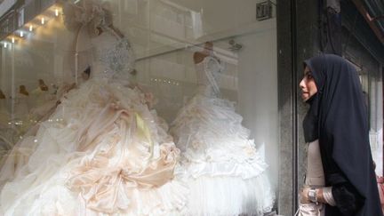 Une Iranienne devant une boutique de robes de mariées à Téhéran. (Atta Kenare / AFP)