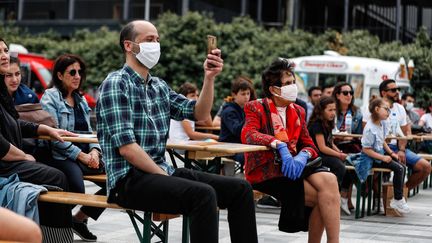 Des spectateurs portent des masques pendant la fête de la Musique, dimanche 21 juin 2020, à l'institut du monde arabe, à Paris. (ABDULMONAM EASSA / AFP)