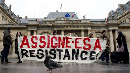 Des opposants aux assignations à résidence prononcées dans le cadre de l'état d'urgence, rassemblés devant le Conseil d'Etat, à Paris, le 11 décembre 2015. (ALAIN JOCARD / AFP)