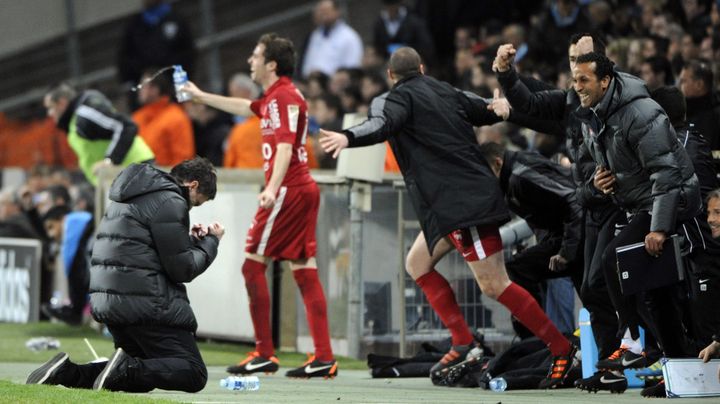 L'entra&icirc;neur de Dijon, Patrice Carteron, en bas &agrave; gauche, c&eacute;l&egrave;bre le but de son &eacute;quipe face &agrave; l'OM, le 17 mars 2012 &agrave; Marseille. (BORIS HORVAT / AFP)