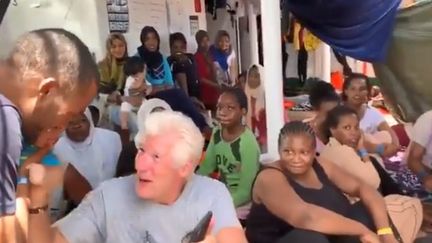 L'acteur Richard Gere&nbsp;aux côtés des migrants, sur le pont du&nbsp;navire "Open Arms", le 9 août 2019, au large de Lampedusa (Italie).&nbsp; (CAPTURE TWITTER OPEN ARMS)