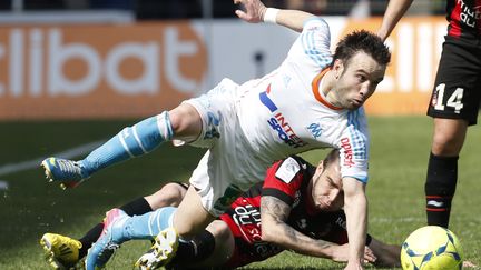 Le joueur marseillais Mathieu Valbuena se d&eacute;barrasse du Ni&ccedil;ois Anthony Bosetti, lors du match opposant les deux &eacute;quipes, le 31 mars 2013.&nbsp; (VALERY HACHE / AFP)