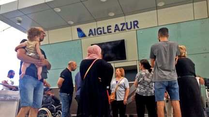 Des passagers attendent près du comptoir de la compagnie Aigle Azur à l'aéroport d'Alger, le 6 septembre 2019. (STRINGER / AFP)