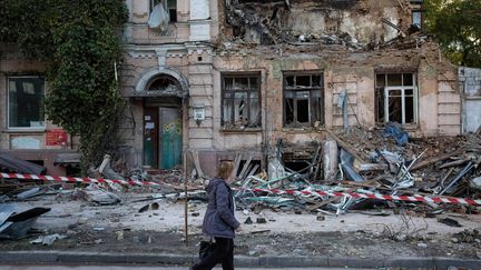 Une femme marche devant un immeuble détruit par la frappe d'un drone, à Kiev (Ukraine), le 17 octobre 2022.&nbsp; (SOPA IMAGES / OLEKSII CHUMACHENKO / SIPA)