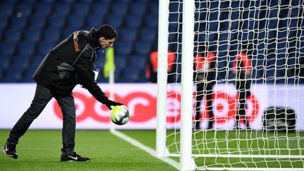 Un homme vérifie la&nbsp;"goal-line technology" avant la rencontre de football Paris-Caen, le 20 décembre 2017. (FRANCK FIFE / AFP)