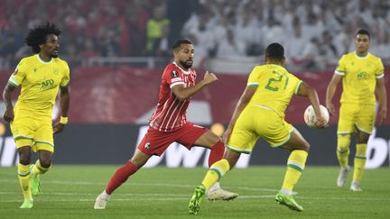 Le Fribourgeois&nbsp;Daniel-Kofi Kyereh (au centre) et le&nbsp;Nantais Moses Simon (à droite) au duel lors de Fribourg-Nantes, le 6 octobre 2022. (THOMAS KIENZLE / AFP)