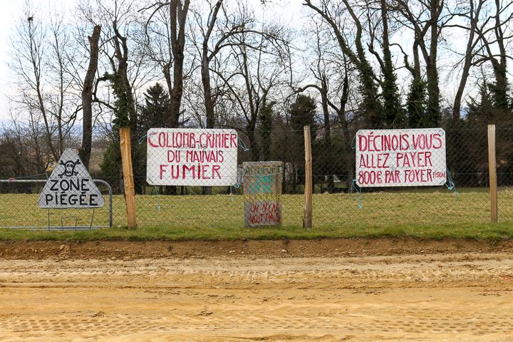 Le long de la future route construite sur son ancien champ, &agrave; D&eacute;cines (Rh&ocirc;ne),&nbsp;Philippe Layat a accroch&eacute; des pancartes d&eacute;non&ccedil;ant le chantier. (BENOIT ZAGDOUN / FRANCETV INFO)