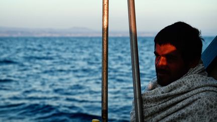 Un migrant sur un bateau de sauvetage de l'ONG SOS Méditerranée (LOUISA GOULIAMAKI / AFP)