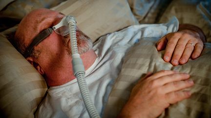 Un homme atteint d'apnée du sommeil dort avec un respirateur (illustration). (GRANDRIVER / GETTY)