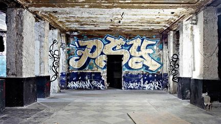 Pilier du graffiti en France, PSY a réalisé une pièce classique, comme surgie du fameux terrain vague de La Chapelle, hôte des débuts du hip-hop français. Ses petits personnages dansants de part et d'autre se prolongent sur une vidéo réalisée par ses soins en "stop motion".
 (Photo Jérôme Coton - Courtesy Magda Danysz)