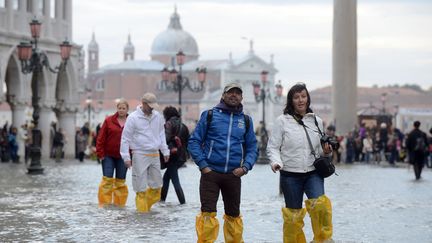 Des touristes traversent la place Saint-Marc inond&eacute;e &agrave; Venise (Italie), le 15 octobre 2012. (ANDREA PATTARO / AFP)