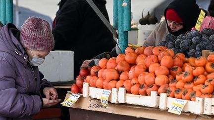 Une femme achète des fruits sur un marché de Moscou (Russie) le 15 décembre 2021&nbsp; (KIRILL KUDRYAVTSEV / AFP)