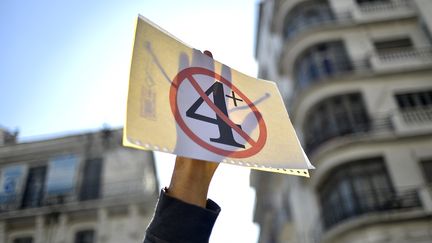 Un étudiant brandit une pancarte dans une manifestation contre la prolongation du mandat d'Abdelaziz Bouteflika, à Alger (Algérie), le 12 mars 2019.&nbsp; (RYAD KRAMDI / AFP)