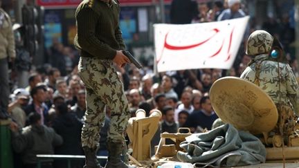 Un soldat égyptien tente de disperser des manifestants en colère pour protéger un policier place Tahrir au Caire, lundi (AFP PHOTO / KHALED DESOUKI)