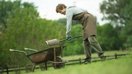 Un jardinier verse une pelletée de terre dans une brouette. (MAXPPP)