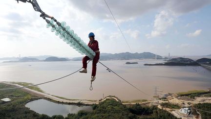 Un &eacute;lectricien travaille sur des c&acirc;bles &agrave; Zhoushan (Chine), le 8 octobre 2012. (QUIRKY CHINA NEWS / REX / SIPA)