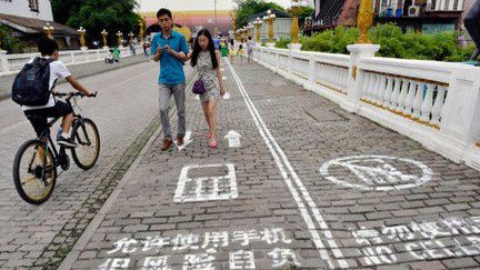 Les accros aux smartphones peuvent maintenant envoyer des textos en toute sécurité dans les rues de Chongqing. (IMAGINECHINA / STRINGER)