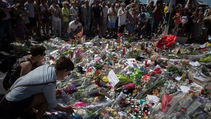 Des habitants déposent des fleurs sur la promenade des Anglais à Nice (Alpes-Maritimes), en mémoire des victimes de l'attentat&nbsp;du 14 juillet, le 16 juillet 2016.&nbsp; (IRINA KALASHNIKOVA / SPUTNIK / AFP)