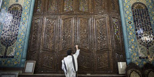 Un fidèle enferme la Torah dans la synagogue Youssef Abad à Téhéran le 30-9-2013. (AFP - Behrouz Mehri)