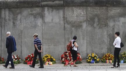 Des fleurs déposées au pied d'un pan conservé du Mur de Berlin, le 13 août 2011 (AFP / Michele Tantussi)