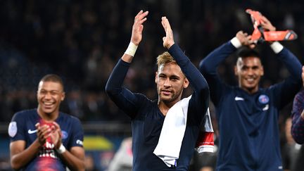 Les joueurs du PSG Kylian Mbappé, Neymar et Alphonse Areola applaudissent en direction des tribunes du Parc des Princes, après leur victoire face à Lyon en Ligue 1,&nbsp;le 7 octobre 2018. (FRANCK FIFE / AFP)