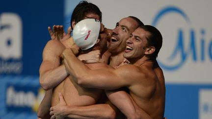 Les nageurs fran&ccedil;ais du relais 4 x 100 m quatre nages, (de gauche &agrave; droite) Camille Lacourt, Fabien Gilot, J&eacute;r&eacute;my Stravius et Giacomo Perez Dortona,&nbsp;apr&egrave;s l'annonce de leur victoire dans le 4 x 100 m quatre nages, le 4 ao&ucirc;t 2013 aux Mondiaux de Barcelone (Espagne). (JAVIER SORIANO / AFP)