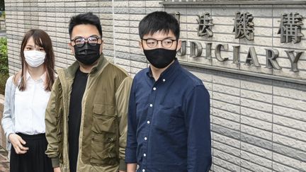 Les militants pro-démocratie Agnes Chow (gauche), Ivan Lam (centre) et Joshua Wong (à droite) arrivent pour leur procès à Hong Kong le 23 novembre 2020. (PETER PARKS / AFP)