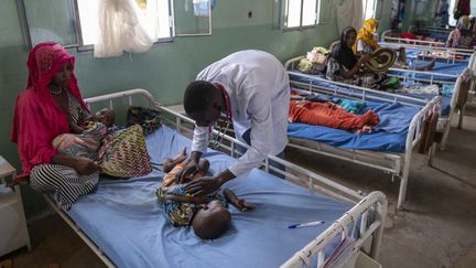 Un médecin examine des enfants souffrant de malnutrition dans un hôpital de&nbsp;N'djamena, au Tchad, le 13 mai 2022. (ANDREW CABALLERO-REYNOLDS / AFP)