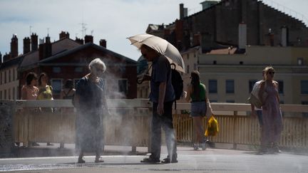 Des passants tentent de se rafraîchir à Lyon (Rhône), ville en proie à de fortes chaleurs, le 18 août 2023. (NICOLAS LIPONNE / HANS LUCAS / AFP)