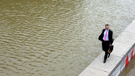 Un pièton marche sur le parapet qui sépare la voie expresse des bords de seine, dans le 12e arrondissement de Paris, le 2 juin 2016. (MAXPPP)