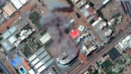 Cette image satellite prise par Maxar Technologies montre de la fumée s'échappant d'un bâtiment près de l'aéroport international de Khartoum, le 17 avril 2023. (SATELLITE IMAGE 2022 MAXAR TECH / AFP)